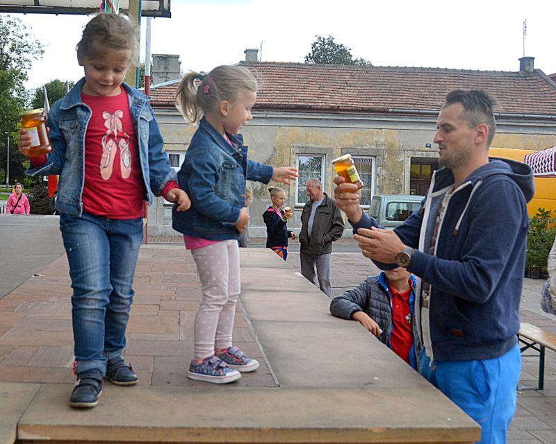 Tata sprawdza nagrodę zdobytą przez córeczkę w konkursie zorganizowanym podczas I Konferencji Pszczelarskiej w Brzesku (02.09.2017 r.). Autor zdjęcia: Marek Kotfis