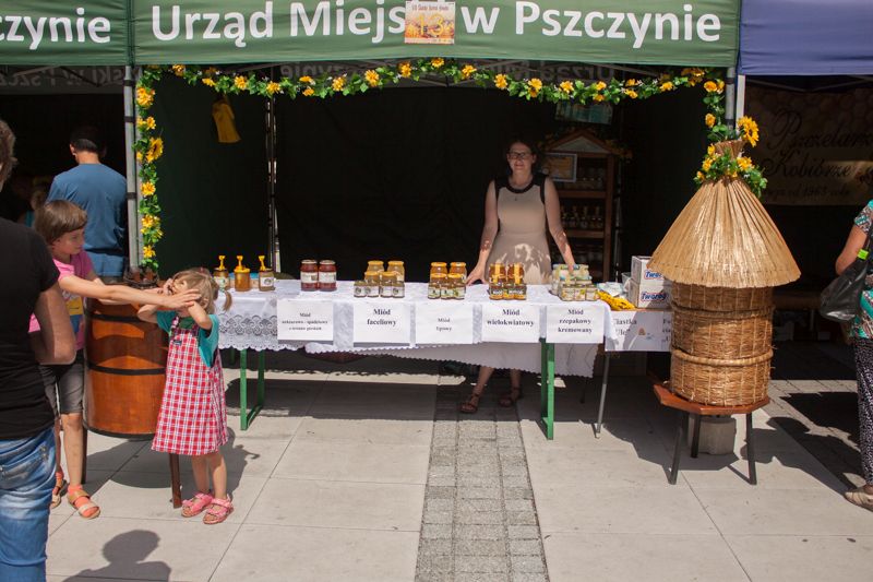 Stoisko pszczelarskie wraz z wyszczególnionym asortymentem (m.in. miodem faceliowym, wielokwiatowym i rzepakowym) podczas wydarzenia o nazwie: VII Święto Miodu w Pszczynie. Autor zdjęcia: Kazimierz Wiśniowski