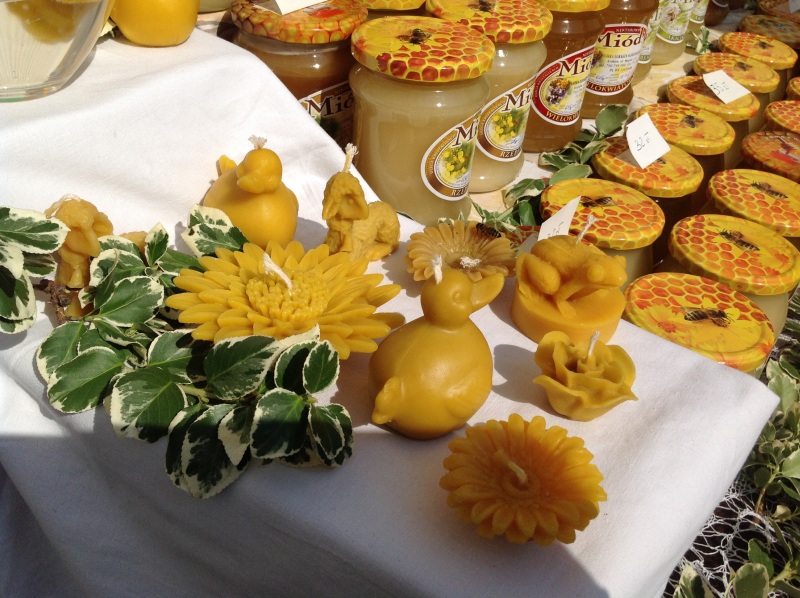 Świeczki z wosku pszczelego. W tle słoiki z miodem. Autorka zdjęcia: Ewa Balana