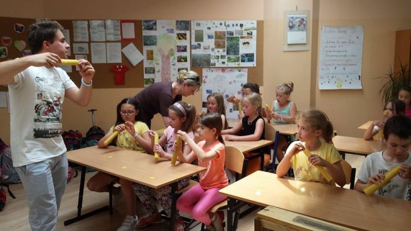 Piotr Nowotnik opowiada uczestnikom warsztatów pszczelarskich o świecach woskowych.