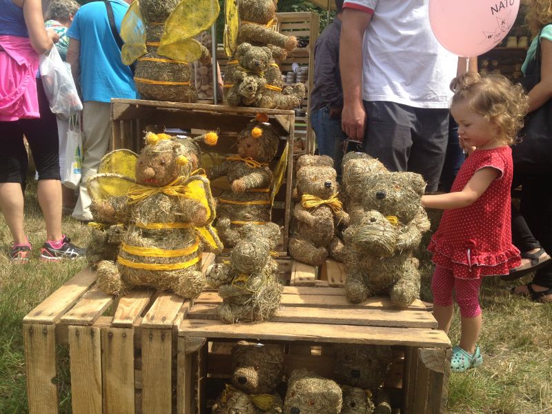 Słomiane maskotki w kształcie niedźwiadka i pszczółki na XV Spotkaniu Pszczelarzy na Trutowisku w Murckach.